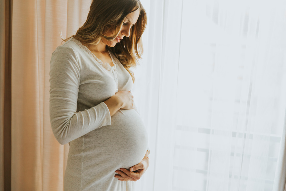 pregnant woman next to window